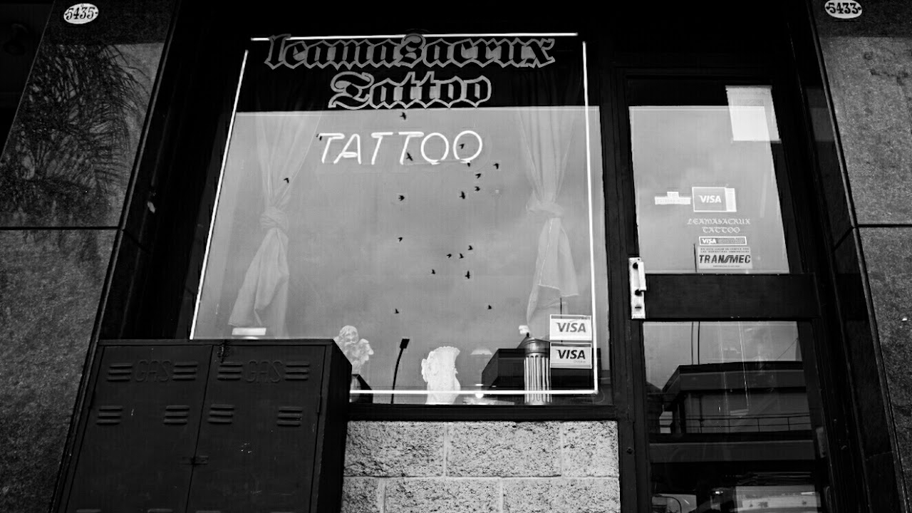 Fachada e interior nocturno de Leamasacrux Tattoo Studio en Flores