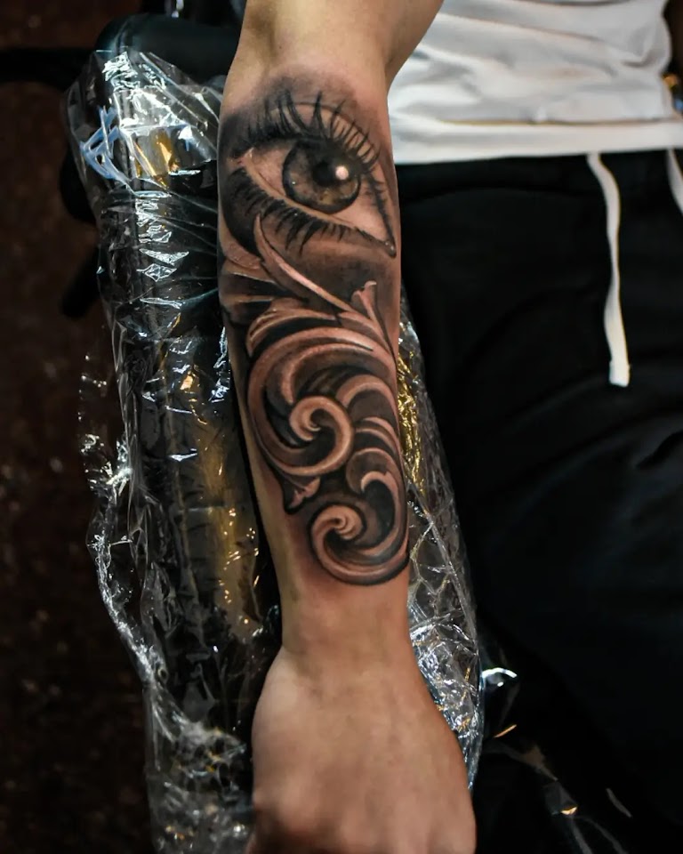 Tatuaje de bíceps con calavera animal realista en black & grey
